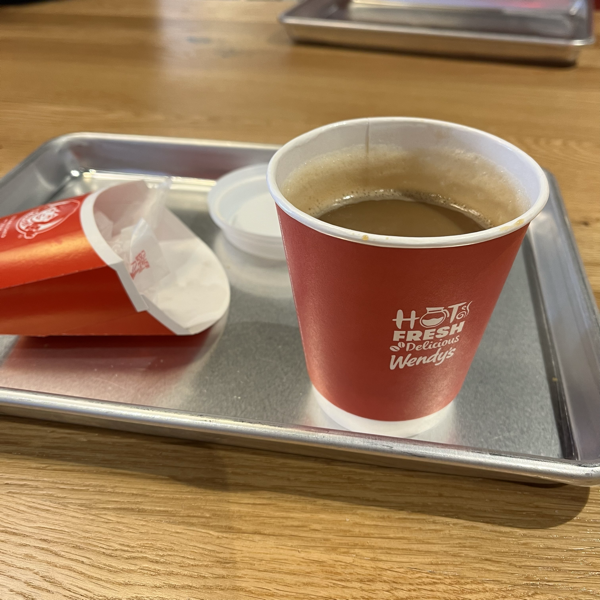 Cup of coffee and empty fries package